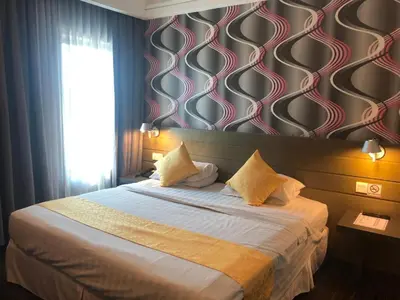 a bedroom with a large bed with a wall at De Hotel Ipoh in Ipoh