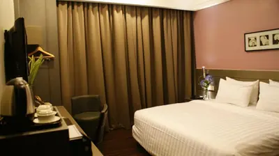 a hotel room with a bed and a television at De Hotel Ipoh in Ipoh
