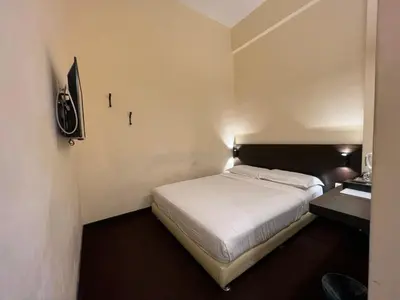 a small room with a bed and a television at SSL Traders Hotel in Taiping