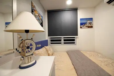 a room with a bed with a fan and a lamp at H2H - Marine Home @ Majestic Ipoh (8~10 Guests) in Ipoh