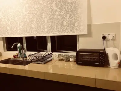 a kitchen counter with a sink and a microwave at House Of Nostalgia in Lumut