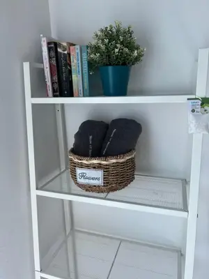 a book shelf with two baskets and a plant at House Of Nostalgia in Lumut