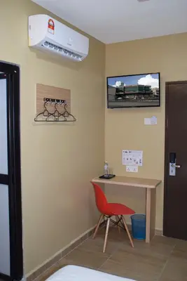 a room with a desk and a red chair at Asiago Hotel in Sungai Petani