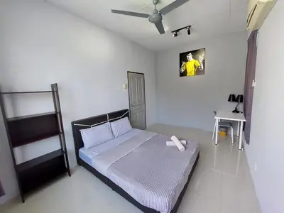 a bedroom with a bed and a tv on the wall at Sea Lion by the beach in George Town