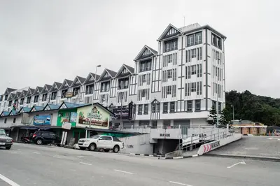 a large white building on the side of a street at Wan Alyasa Hotel in Cameron Highlands