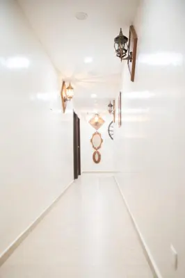a hallway with white tile floors and lights at Wan Alyasa Hotel in Cameron Highlands