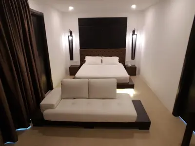 a hotel room with two beds and a couch at Hermitage Boutique House in Taiping