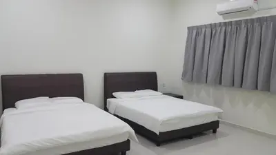 two beds in a room with white sheets at My STW Home 1 in Sitiawan