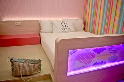 a bedroom with a bed with a laptop on it at Iconic Suites & Pods Hotel in Ipoh