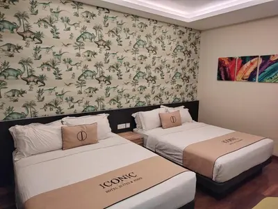 two beds in a hotel room with a wallpaper at Iconic Suites & Pods Hotel in Ipoh
