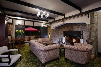 a living room with couches and a stone fireplace at The Lakehouse Cameron Highlands in Ringlet