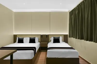 a room with two beds and a table in it at Collection O GHC Near Penang Street Art Formerly Queen City Hotel in George Town