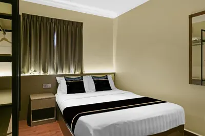 a bedroom with a white bed with a window at Collection O GHC Near Penang Street Art Formerly Queen City Hotel in George Town
