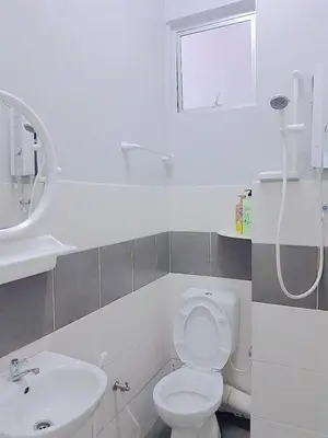 a white bathroom with a toilet and a sink at Triple J in Cameron Highlands