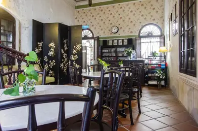 a restaurant with tables and chairs in a room at Carnarvon House in George Town