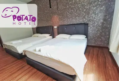 two beds sitting next to each other in a room at Potato Hotel in Taiping