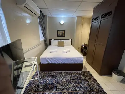 a small room with a bed and a glass table at Barrack Street Hotel in Taiping
