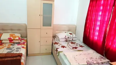 a small bedroom with two beds and a cabinet at Homestay Ahmad Kuala Kangsar in Kuala Kangsar