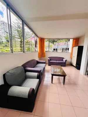 a living room with couches and a table and windows at KRS Pines GuestHouse in Cameron Highlands