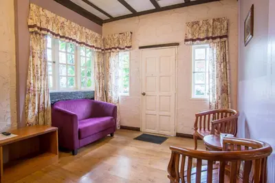 a living room with a purple chair and a window at The Bala's Holiday Chalet in Cameron Highlands