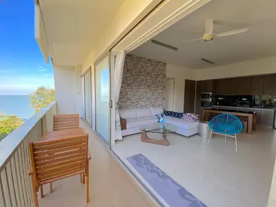 a balcony with a living room and a kitchen at By The Sea Suite,Batu Ferringhi in Batu Ferringhi