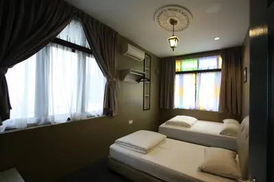 two beds in a room with two windows at Shamrock Greenhill in Ipoh