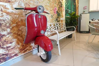 a red scooter parked next to a wall at \u5bb6 Majestic Ipoh in Ipoh
