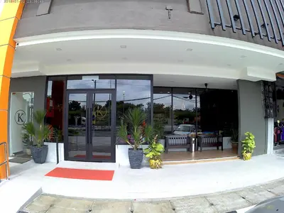 a store front with glass doors and potted plants at K Boutique Hotel in Teluk Intan