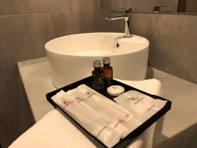 a bathroom with a sink and a tray with towels at K Boutique Hotel in Teluk Intan