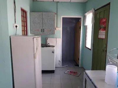a kitchen with a white refrigerator in a room at Homestay Ustaz in Taiping
