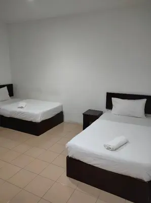 a room with two beds with white sheets at Hotel Star Inn in Teluk Intan