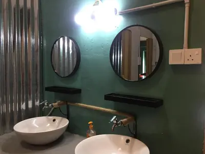 a bathroom with two sinks and two mirrors on the wall at Hikers Sleep Port Guesthouse in Cameron Highlands