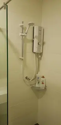 a bathroom with a shower and a hair dryer on a wall at SL TR Homstay in Cameron Highlands