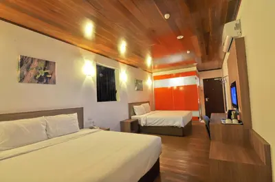 a bedroom with two beds and a wooden ceiling at Greencity Hotel in Sungai Petani