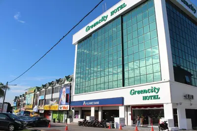 a large glass building on a city street with cars at Greencity Hotel in Sungai Petani