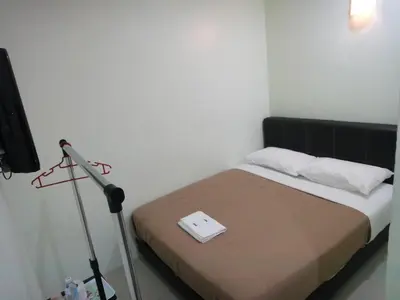 a room with a bed with a tripod and a television at Mines Inn Hotel in Gua Musang
