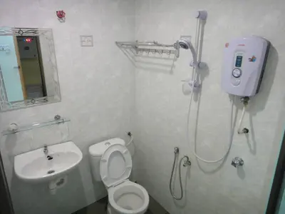 a bathroom with a shower and a toilet and a sink at Mines Inn Hotel in Gua Musang
