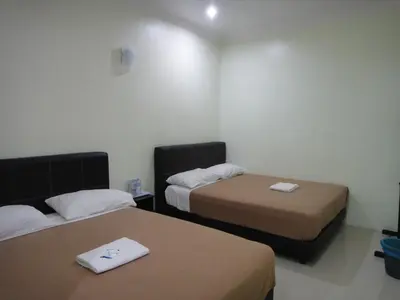 two beds in a hotel room with two bedsvisor at Mines Inn Hotel in Gua Musang