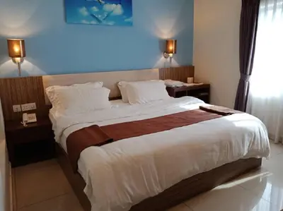 a bedroom with a large bed with a blue light at Oscar Suites Hotel in Sitiawan