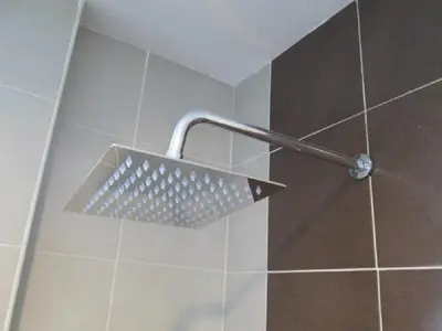 a shower with a shower head in a bathroom at Oscar Suites Hotel in Sitiawan