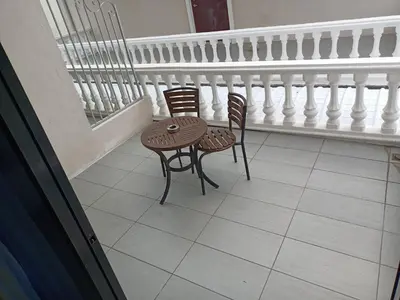 two chairs and a table on a balcony at Oscar Suites Hotel in Sitiawan