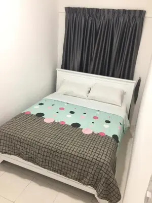 a small bedroom with a bed with a floral bedspread at Cameron Prima Apartment @ Cameron Jaya in Cameron Highlands