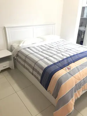 a bed with a striped blanket on it in a room at Cameron Prima Apartment @ Cameron Jaya in Cameron Highlands