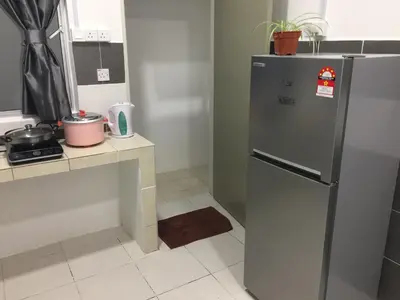 a kitchen with a stainless steel refrigerator and a counter at Cameron Prima Apartment @ Cameron Jaya in Cameron Highlands
