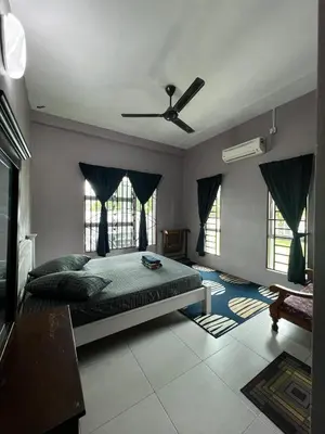 a bedroom with a bed and a ceiling fan at Taiping Homestay Husna Afina in Taiping