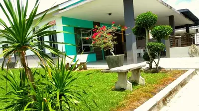 a bench in front of a building with plants at Taiping Homestay Husna Afina in Taiping