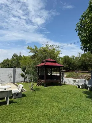 a gazebo with a table and benches in a yard at Taiping Homestay Husna Afina in Taiping
