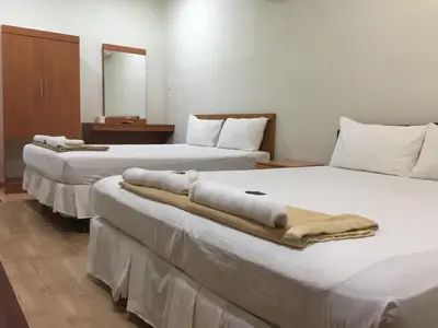 three beds in a hotel room with towels on them at Hotel Sri Malim in Tanjung Malim