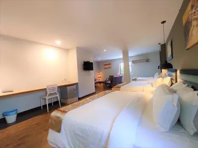 a hotel room with two beds and a desk at Apple Suites Hotel in Sitiawan