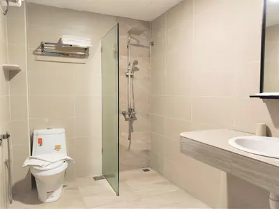 a bathroom with a shower and a toilet and a sink at Apple Suites Hotel in Sitiawan